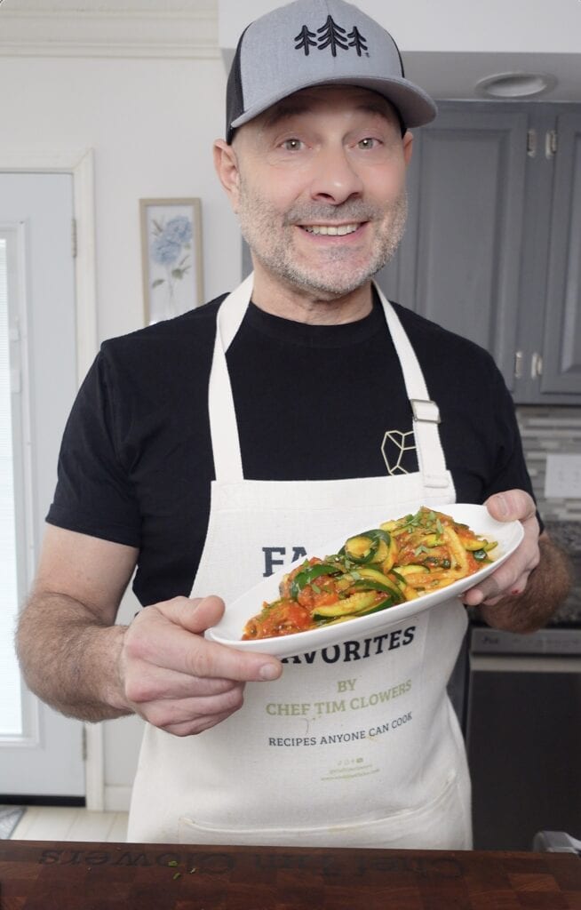 Tim holding a plate of Zucchini Pasta.